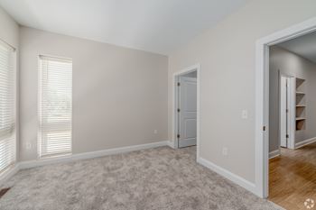 A room with a carpeted floor and a door.